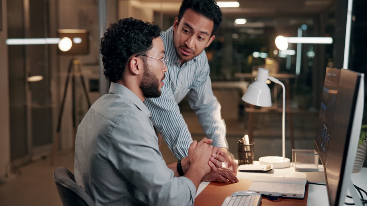 Two Businessmen Collaborating and Discussing Data on Computer