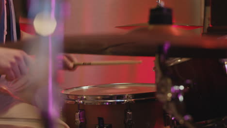 young male musician playing drums in recording studio