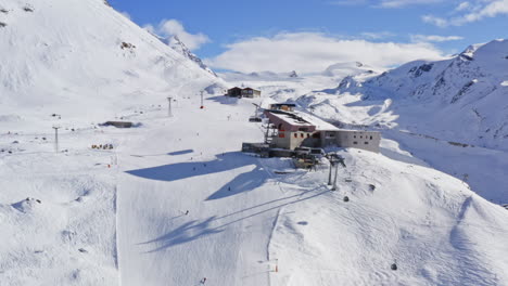 aerial drone overview of ski resort and skiers going downhill in the alps