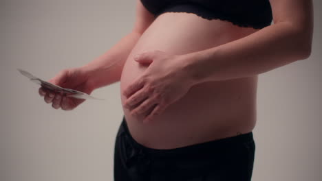 pregnant woman looks through ultrasound photos while awaiting baby