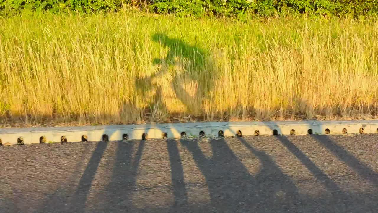 Foto sombreada de um ciclista de estrada pedalando rápido em uma via pública do Reino Unido