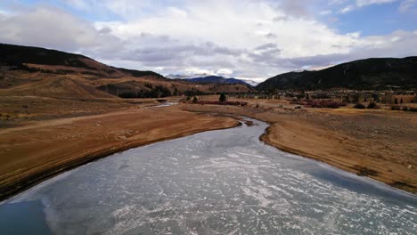 drone aerial view flying over small river stream with dry yellow riverbanks in colorado countryside near sapphire point dillon reservoir