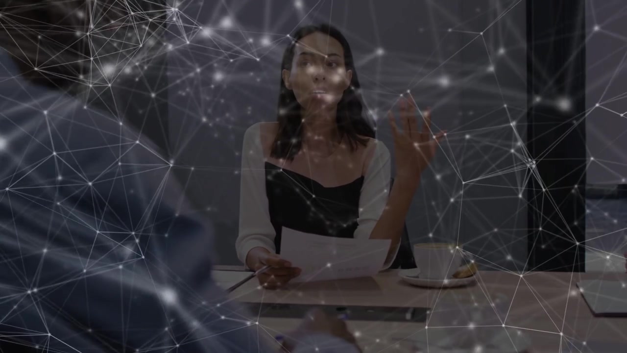 Donna che consulta una pagina, alzando la mano per guidare una riunione di lavoro, con un overlay di rete che reagisce.