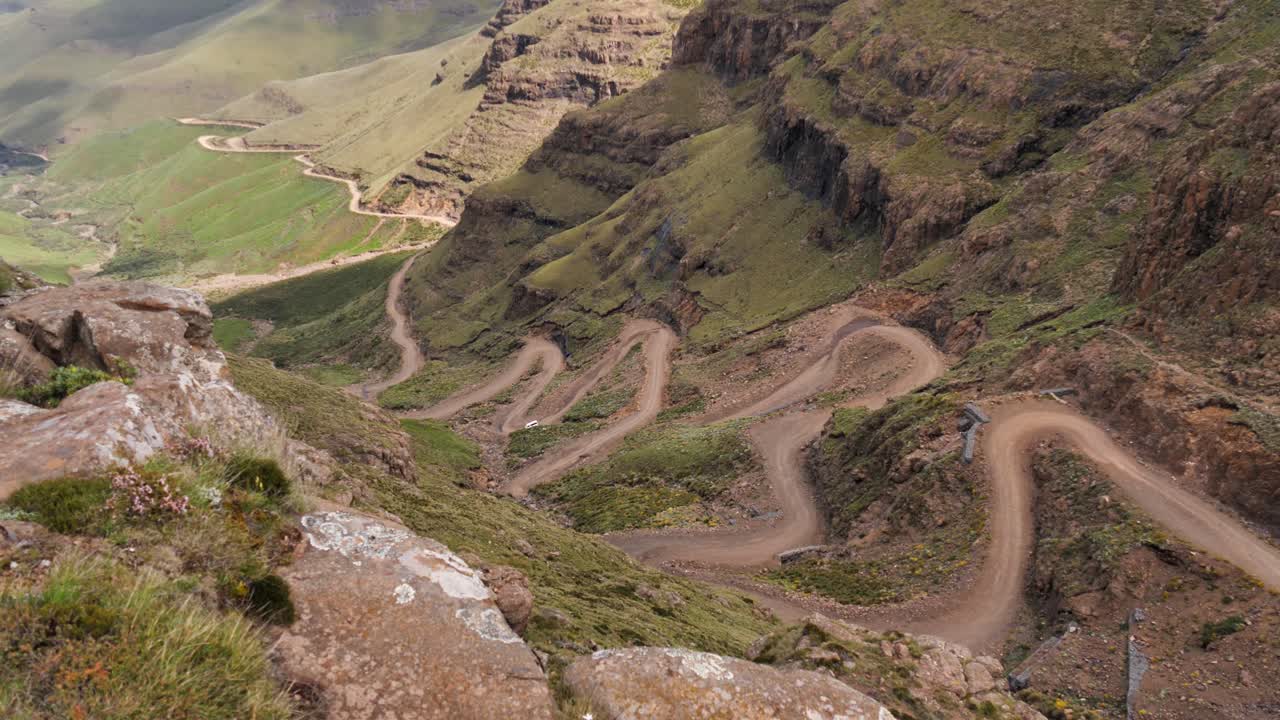 un camión solitario conduce por zigzags accidentados y peligrosos de sani pass
