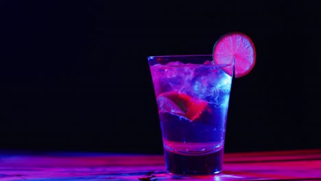 close up of drink with lemon on black background, with copy space