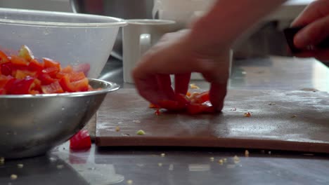 un chef aplana trozos de pimiento para cortarlos y cortarlos en cubitos sin esfuerzo, listos para una gran comida
