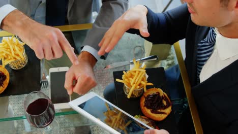 two people watching their tablet and shaking hands