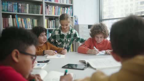 blonde girl comes to talk to boys sitting at round table