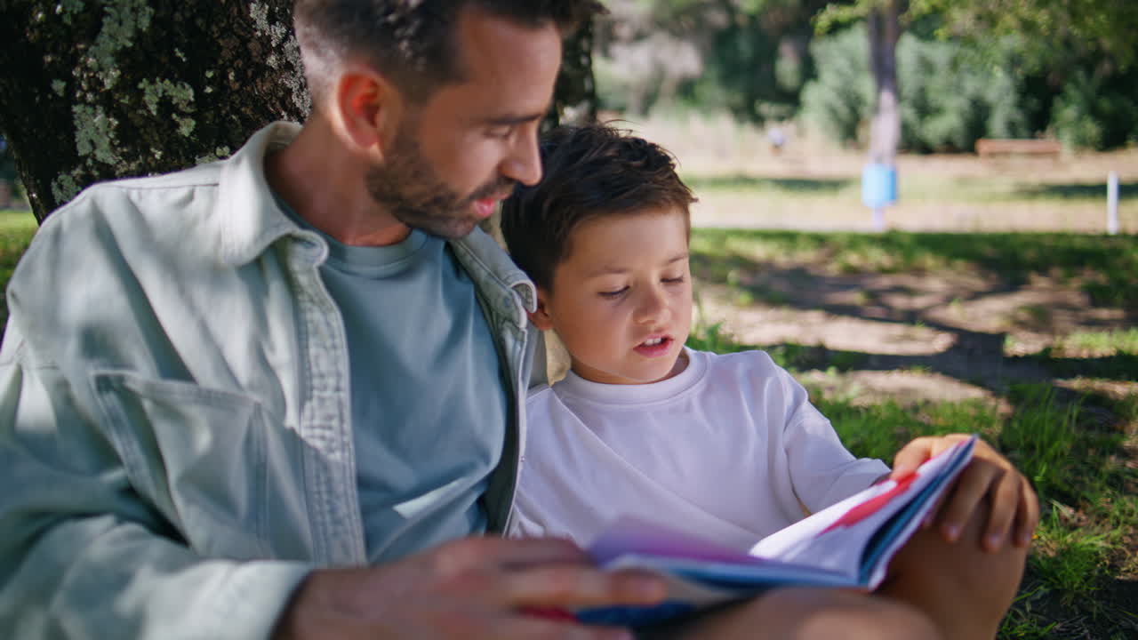 Daddy child reading fairytale gathering in forest closeup. Father son talking