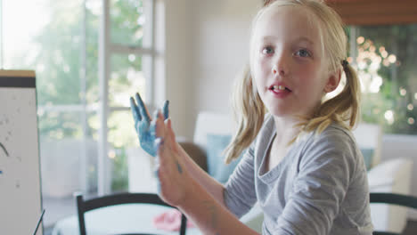 Side-view-of-Caucasian-girl-painting-at-home