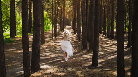 woman in wedding dress and sports shoes runs along forest