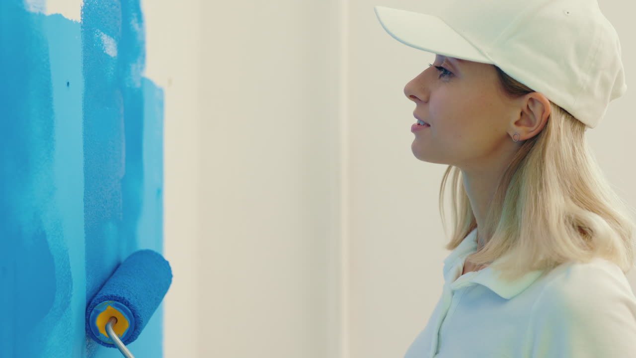 Woman painting a wall blue