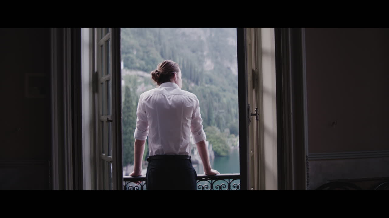 Man looking out of a window at a scenic view