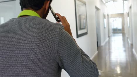 Male-executive-talking-on-mobile-phone-while-cycling