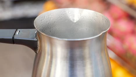 close-up of a metal cezve with condensation