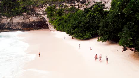 Man-runs-shirtless-along-picturesque-Kelingking-Nusa-Penida-beach-Bali-Indonesia