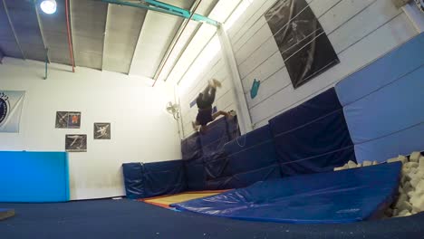 a slow motion still shot of a guy doing flips from the trampoline landing and winning having fun and working out in 60fps