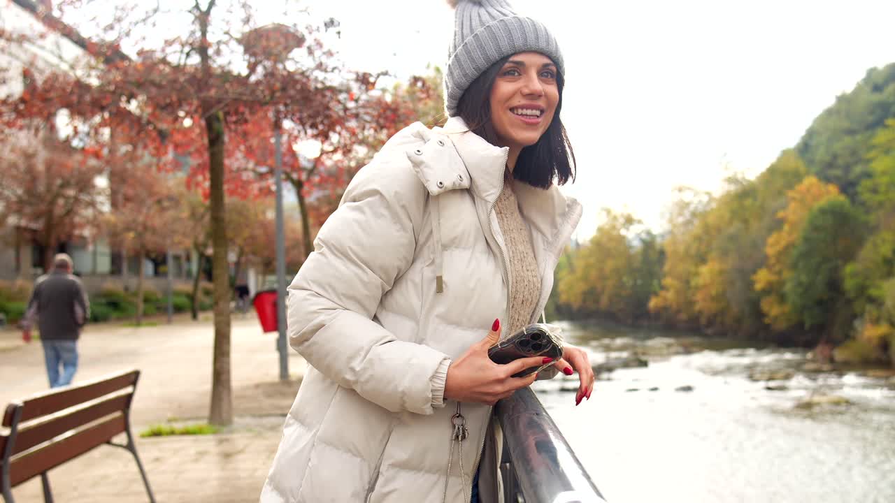 Woman in winter outerwear by the river