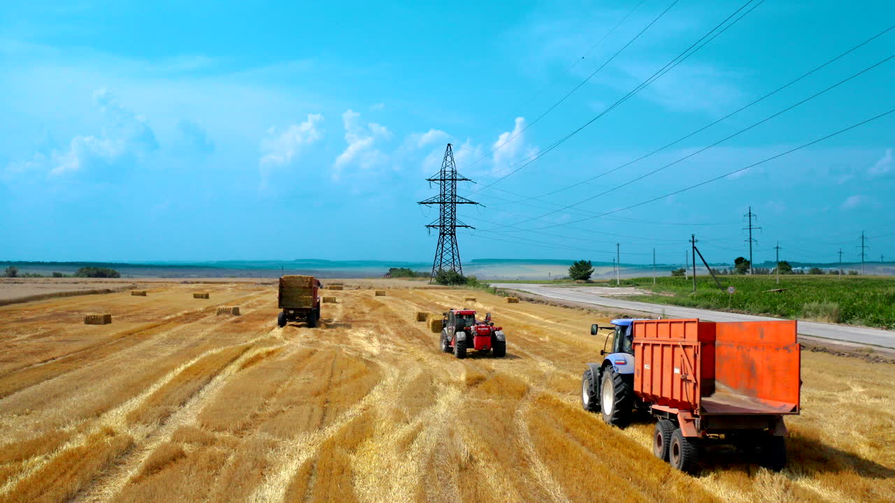 Aerial view of tractor collects the hay. Piles of hay getting collected by agricultural machines in haystack