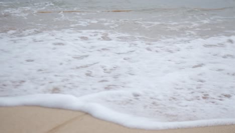 a rope with crashing waves on the sandy shore. close-up shot