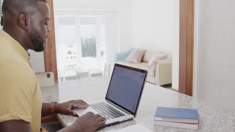 hombre afroamericano usando una computadora portátil con espacio de copia en la pantalla, en cámara lenta