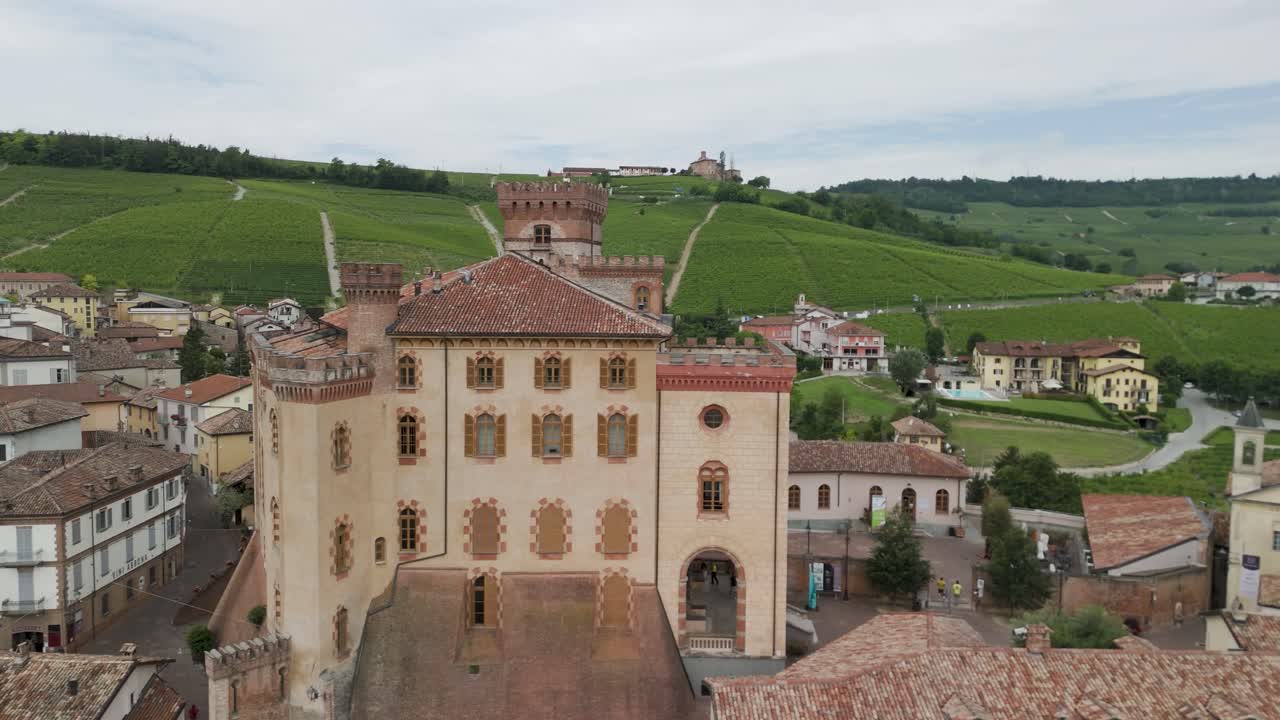Barolo Castle in Langhe Wine Region, Cuneo, Piedmont, Italy. 4K Aerial view of the village and the vineyards circling to the right.