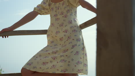 relaxed woman leaning railings on seashore. girl posing on beach wearing dress.