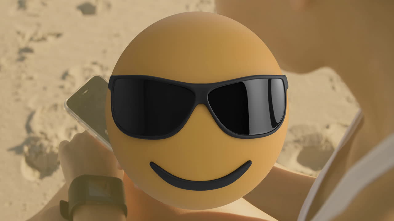 On sandy beach, person using smartphone with cool emoji animation sunglasses