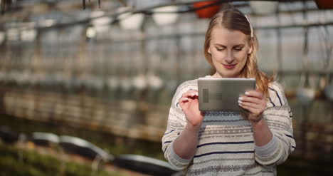 Female-Gardener-Using-Digital-Tablet-In-Greenhouse-4