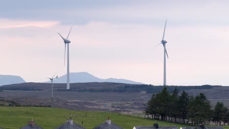 shot of two wind turbines on a hill