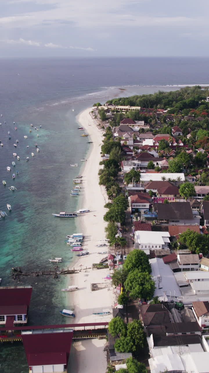 Vertical drone shot overlooking a beach and town in Gili Trawangan, Indonesia