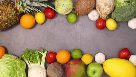 fresh organic heathy fruits and vegetables move on top and bottom of dark kitchen table. stop motion