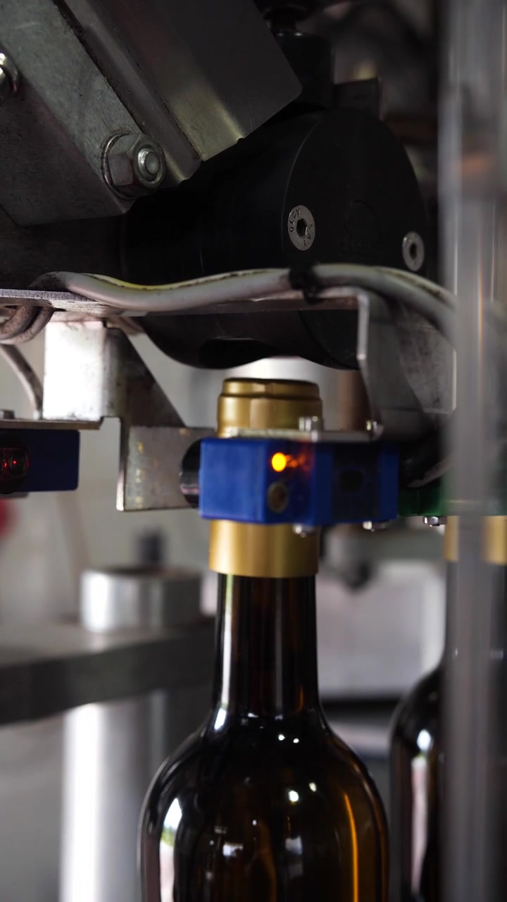 Red wine production process, bottles being corked.