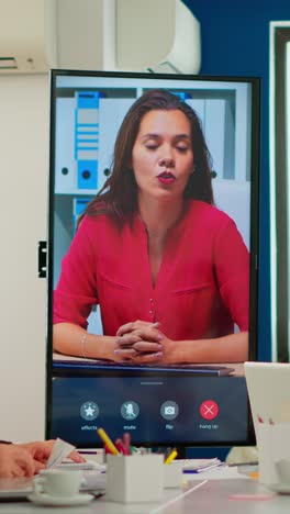 vertical video diverse executive team meeting at conference video call looking at huge display