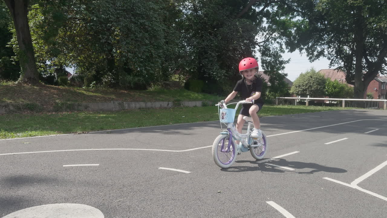 A happy toddler rides a bicycle around a park while learning important highway code rules for safe biking