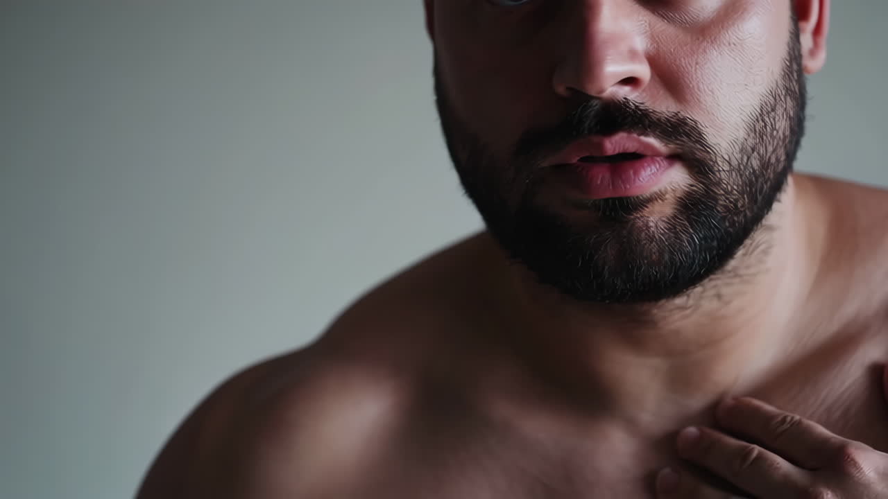 Close-up portrait of a man with a beard and muscular chest