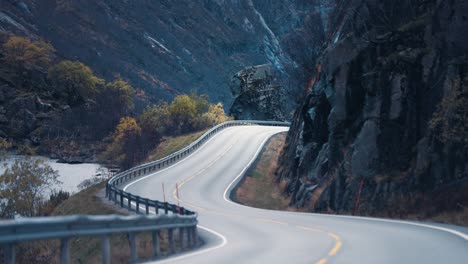 Two-lane-country-road-winds-between-the-steep-rocky-slopes