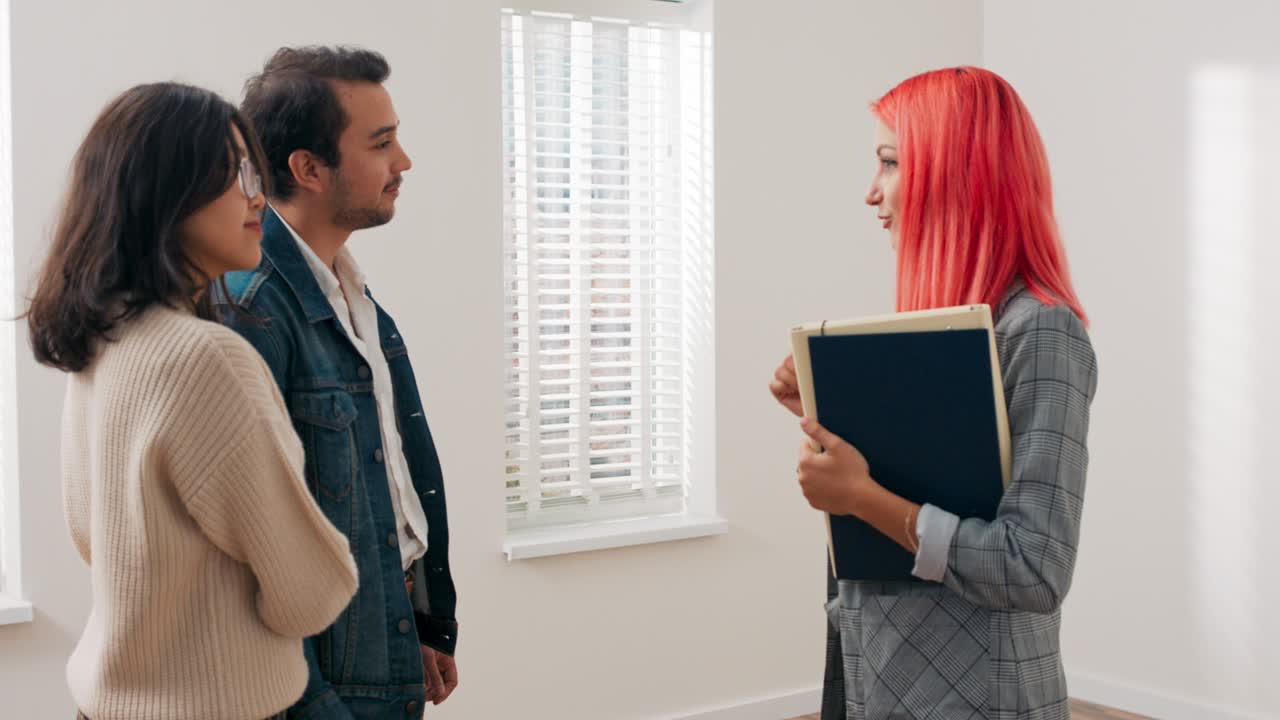viendo apartamento para venta, alquiler a inquilinos potenciales, pareja joven está hablando en la habitación con el agente de bienes raíces, están discutiendo haciendo preguntas negociando precio mujer está tratando de dar respuestas