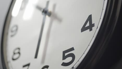 white clock face close up in time lapse on dark grey wall