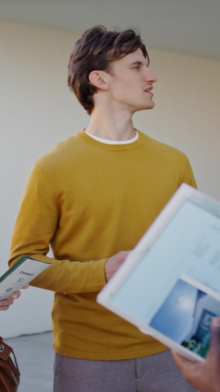 Man holding brochures outdoors