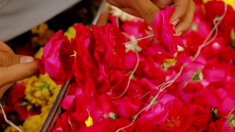 vendedor de flores que hace guirlandas de flores hindúes para la decoración del templo, ofrenda. jodhpur, rajasthan, india
