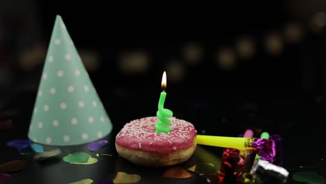 Party.-Pink-donut-and-a-red-festive-candle-on-it.-Golden-confetti-fall