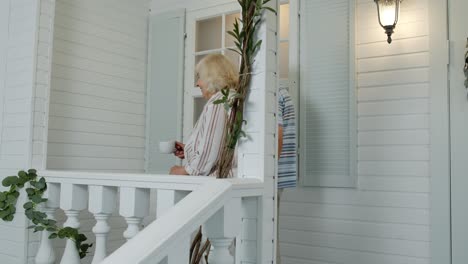 senior elderly couple drinking coffee, looking ahead in porch at home. mature family in own house