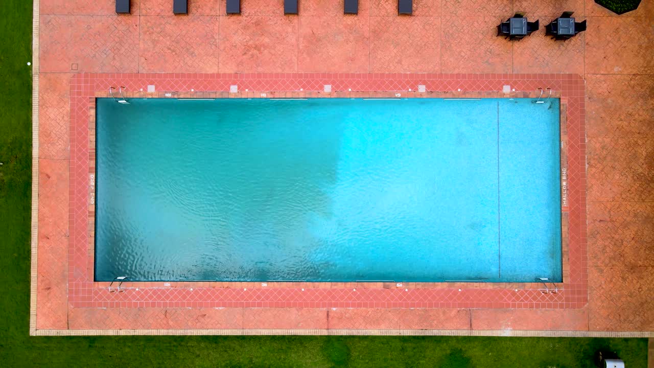 Swimmingpool på et feriested med en grøn plæne