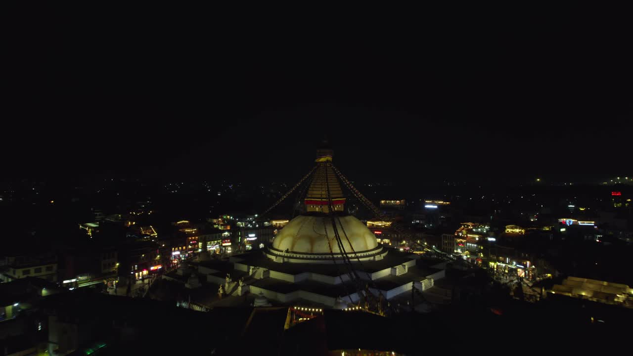 A serene night drone view of Boudhanath Stupa, a UNESCO world heritage site. The sacred Buddhist landmark glows beautifully above Kathmandu’s peaceful evening skyline