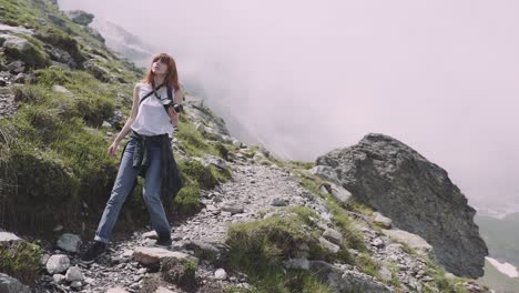 una joven excursionista sube montañas con una cámara fotográfica. transfagarasan, montañas de los cárpatos en rumania
