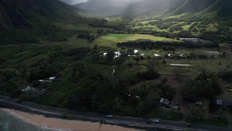 Tilting-up-aerial-shot-to-reveal-the-epic-Jurassic-Valley-vista-with-sun-rays-peeking-through-the-clouds-on-the-island-of-O'ahu,-Hawaii