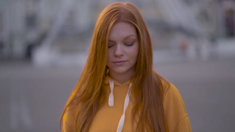 Young-Pretty-Red-Haired-Woman-Smiling-And-Looking-At-Camera-Outdoors