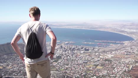 cámara lenta: el hombre en la montaña de la mesa disfruta de una hermosa vista de ciudad del cabo