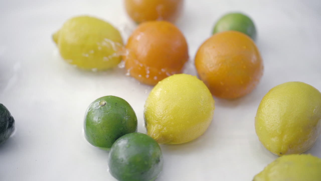 slomo de cítricos en agua sobre fondo blanco